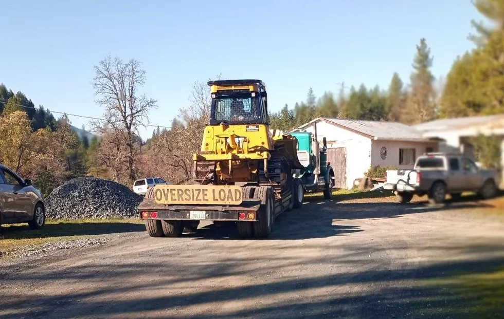NEE Excavation lowboy trailer hauling the backhoe